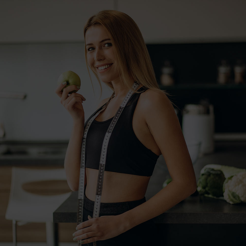 Happy thin woman walking on the beach in jean shorts and a bikini top after gastric bypass